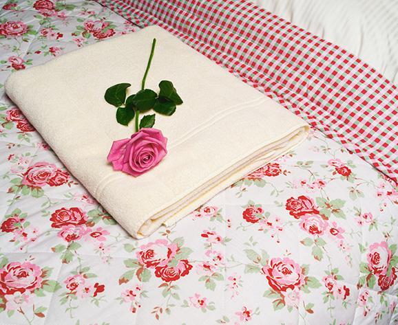 Ręcznik na łóżku i róża